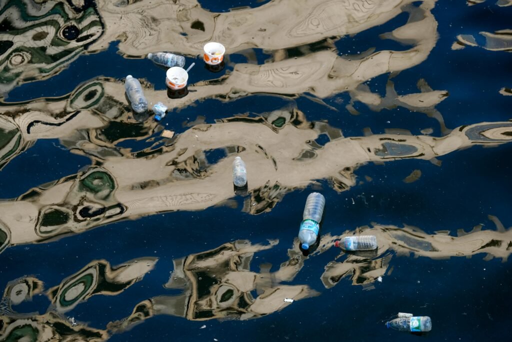 Plastic bottles and waste floating in polluted water highlighting ocean cleanup efforts and robotic solutions for marine pollution