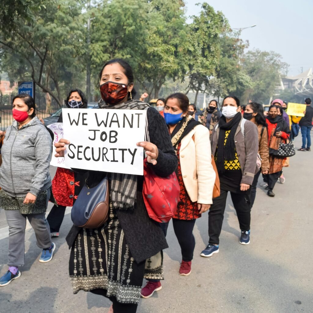 Women protesting for job security and workers’ rights during a public march highlighting employment and social issues
